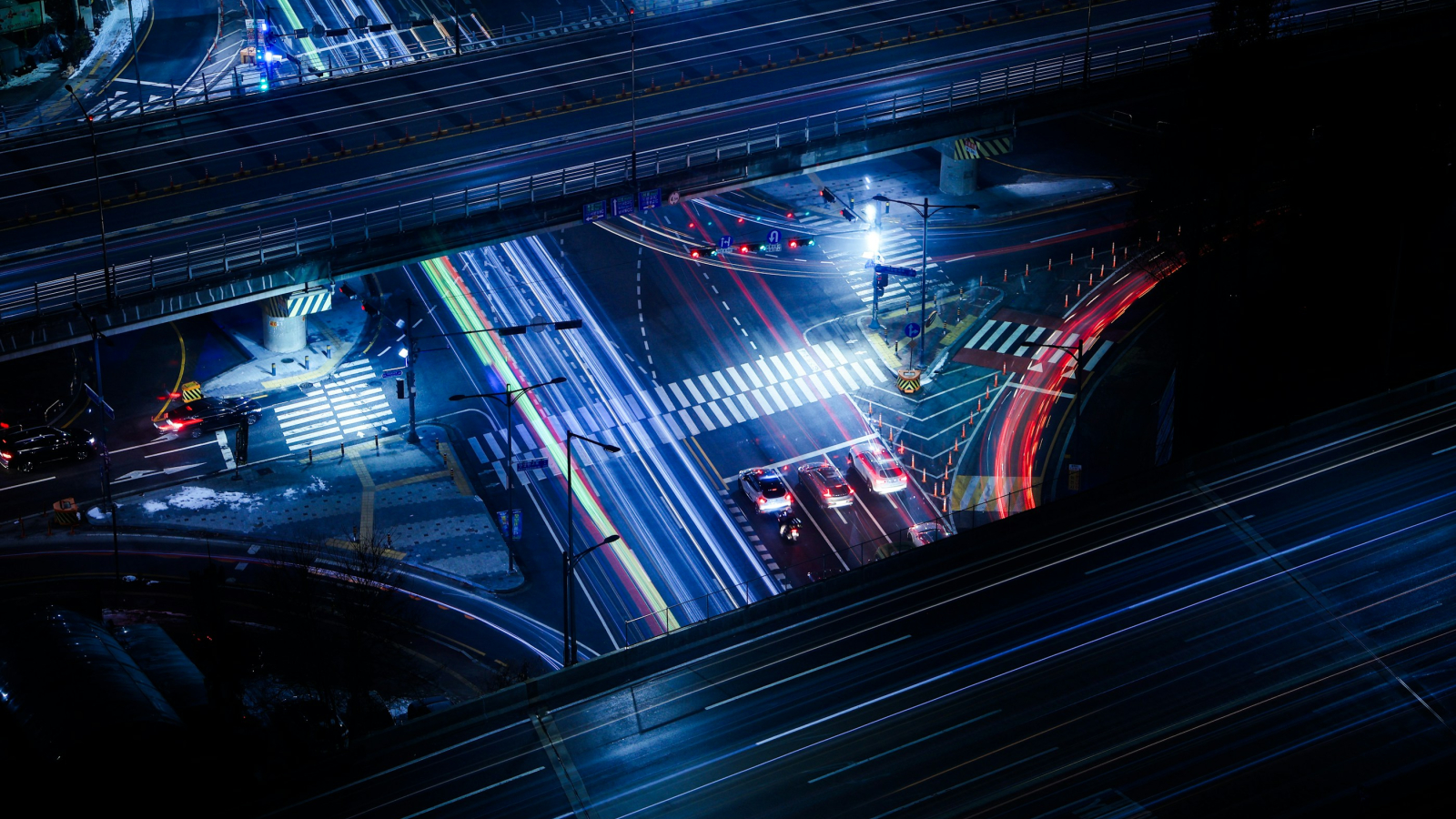 Nachtbeeld van een druk viaduct met meerdere wegen over- en door elkaar heen